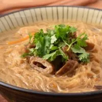 Overhead view of vermicelli noodles in broth.