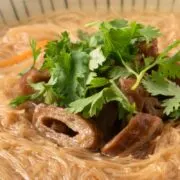 Overhead view of vermicelli noodles in broth.