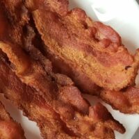 Plate of crispy, cooked bacon.