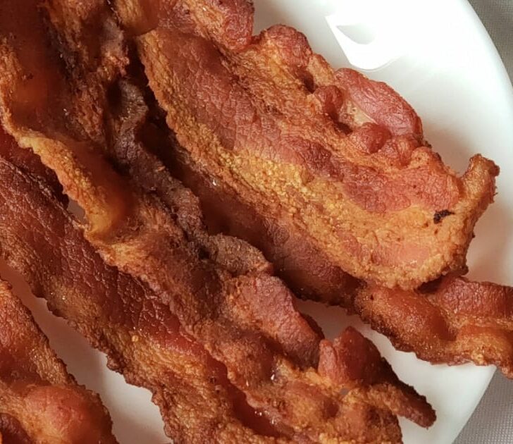Plate of crispy, cooked bacon.
