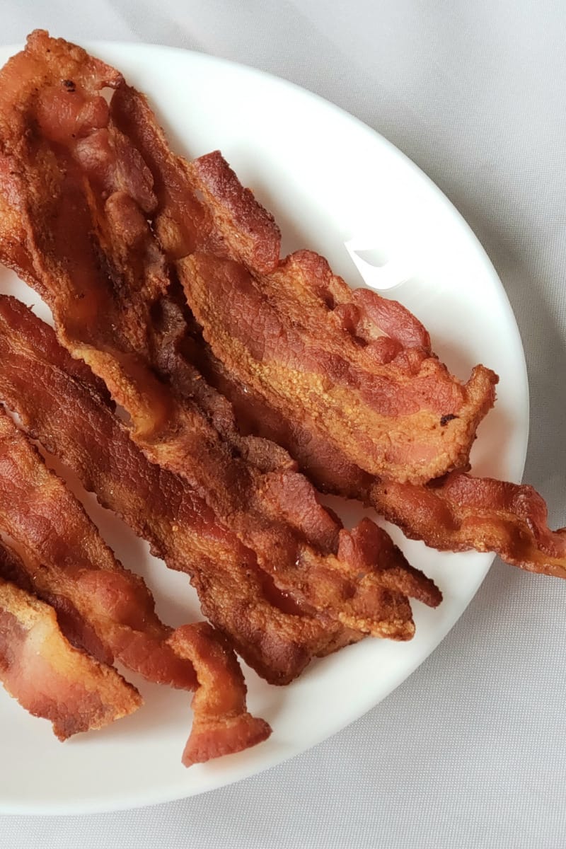 Plate of crispy, cooked bacon.