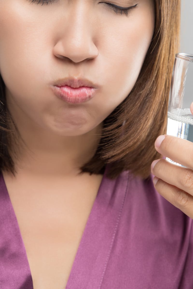 Woman with soapy taste in mouth gargles.