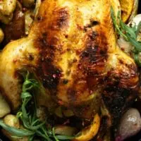 Top view of cornish game hen on serving platter with vegetables.