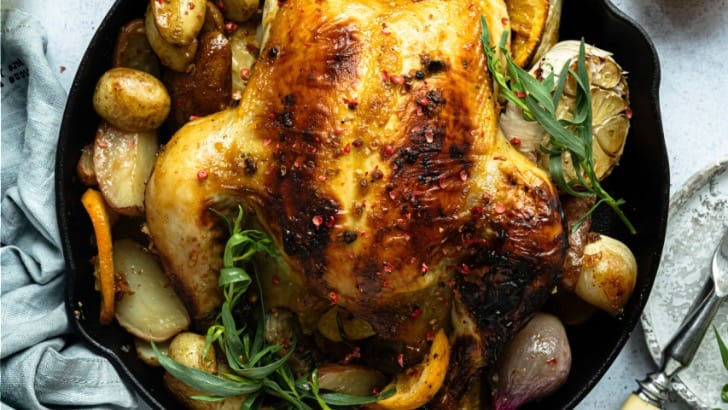 Top view of cornish game hen on serving platter with vegetables.