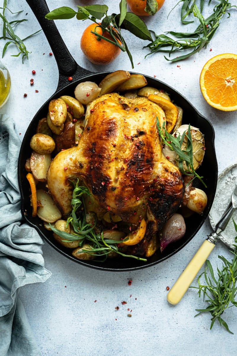 Top view of cornish game hen on serving platter with vegetables.