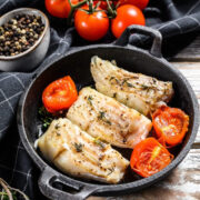 Overhead view of codfish cooked in a pan.