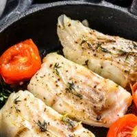 Overhead view of codfish cooked in a pan.