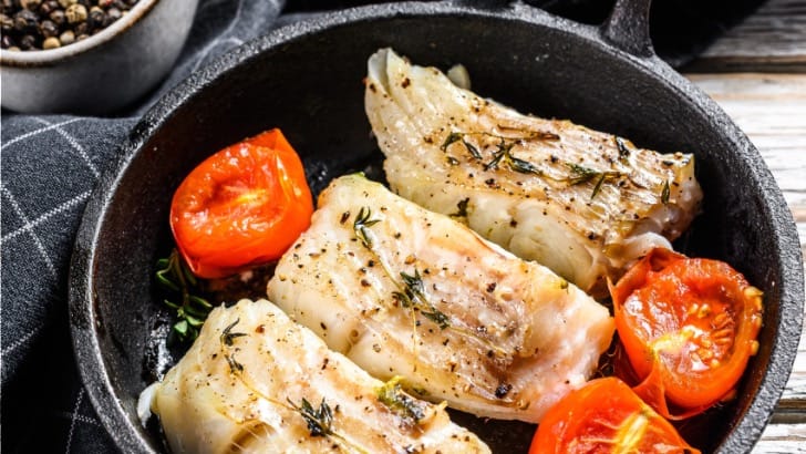 Overhead view of codfish cooked in a pan.