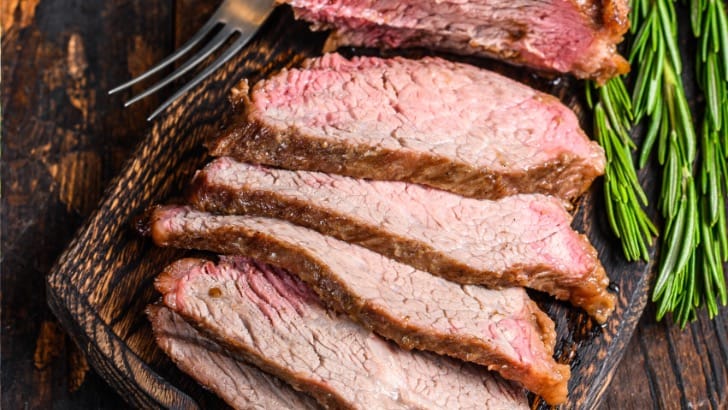 Slices of prepared tri-tip steak on platter.