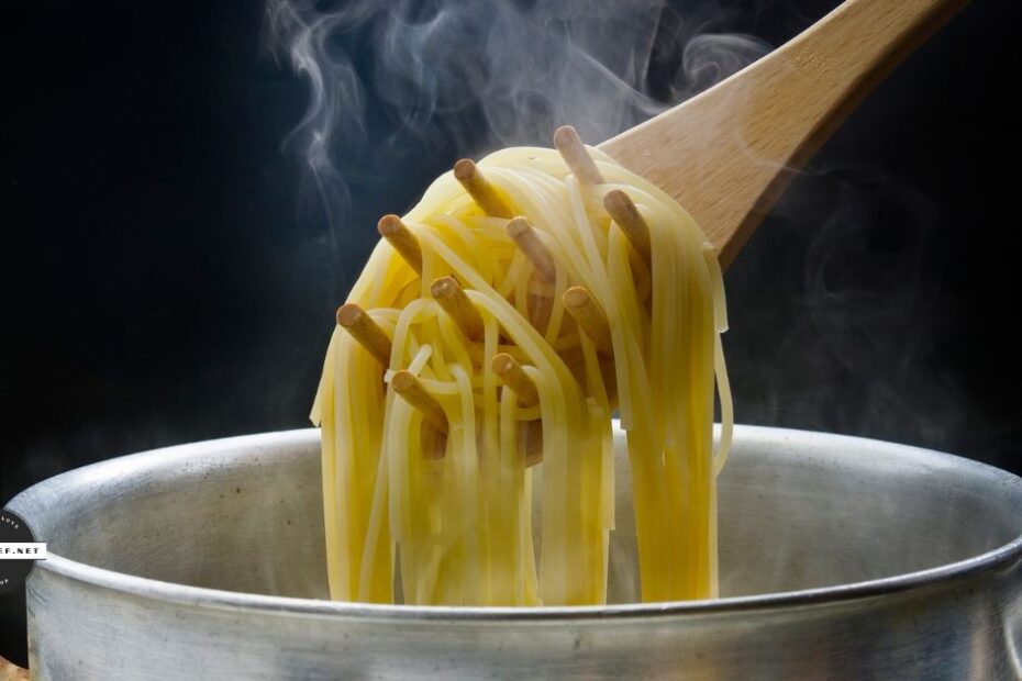Wooden spoon holding pasta noodles above pot