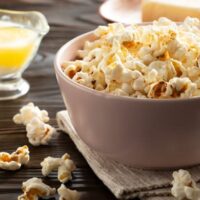 Bowl of popcorn with butter flavoring on table to represent how to substitute for butter flavoring.