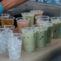 Multiple prepared taro tea drinks on table.