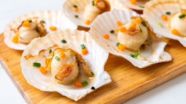 Prepared scallops on cutting board.