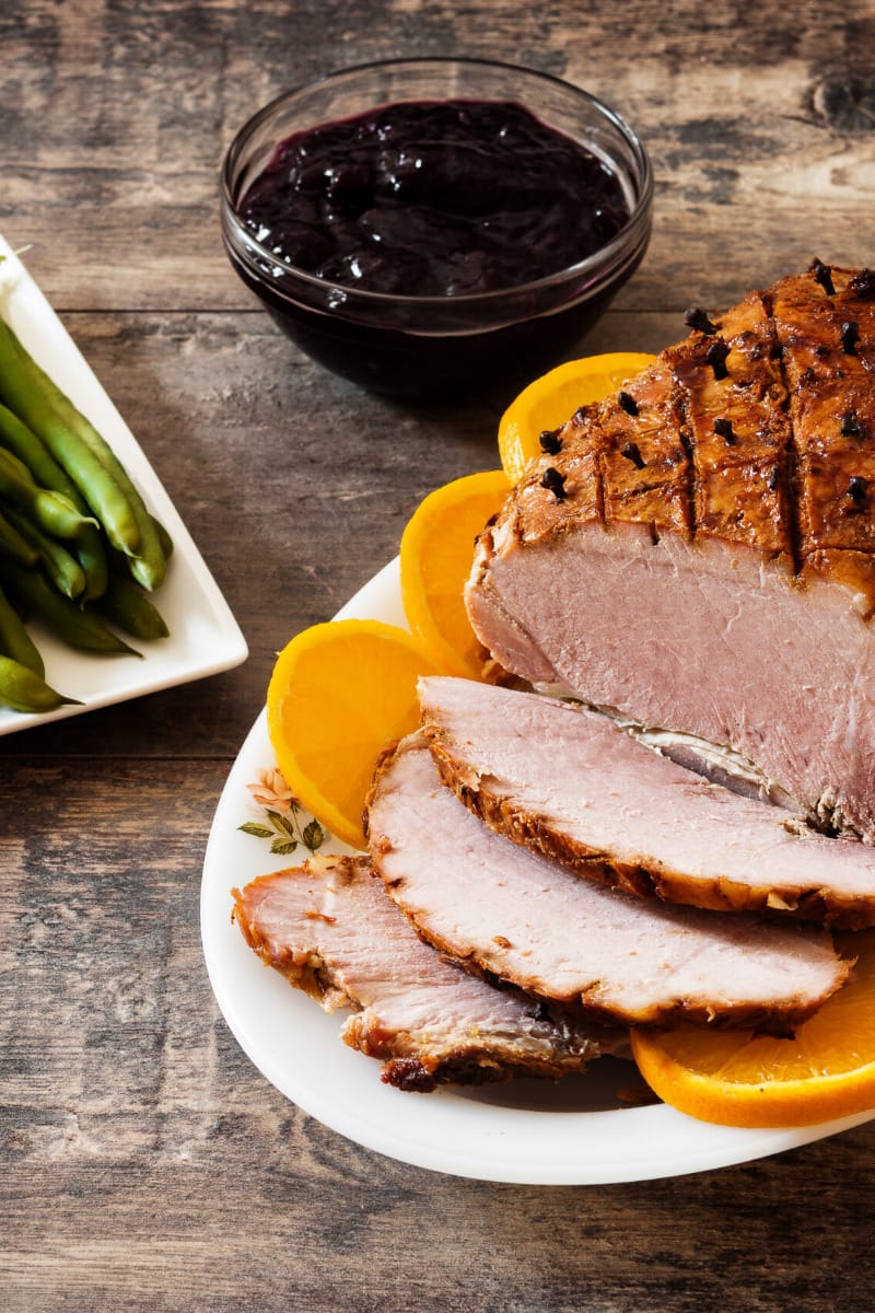 Prepared butt ham on table with side dishes. 