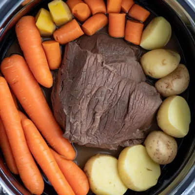 Top view of chuck roast inside Instant Pot with carrots and potatoes.