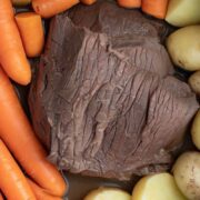 Top view of chuck roast inside Instant Pot with carrots and potatoes.