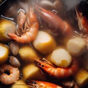 Top view of shrimp boil with potatoes and corn in pot.