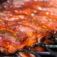 Baby back ribs cooking on gas grill.