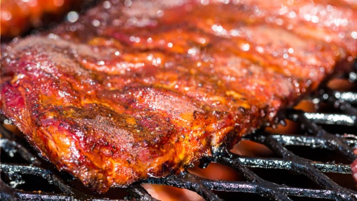 Baby back ribs cooking on gas grill.