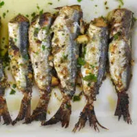 Top view of whole sardines prepared on plate.