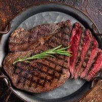 Top view of grilled steak, cooked to medium rare and sliced.