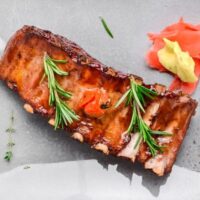 Overhead view of prepared baby back ribs on serving tray.