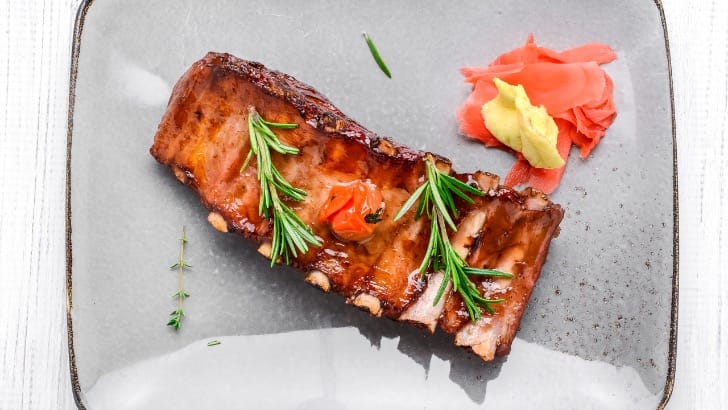 Overhead view of prepared baby back ribs on serving tray.