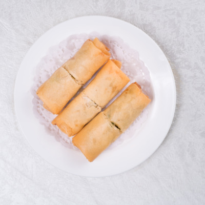 Overhead view of three egg rolls after being cooked in air fryer.