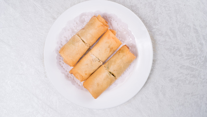 Overhead view of three egg rolls after being cooked in air fryer. 