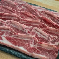 Raw boneless beef ribs on tray.