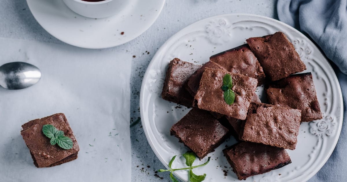 Chocolate brownie squares on serving plate.