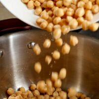 Pouring soaked beans into pot.