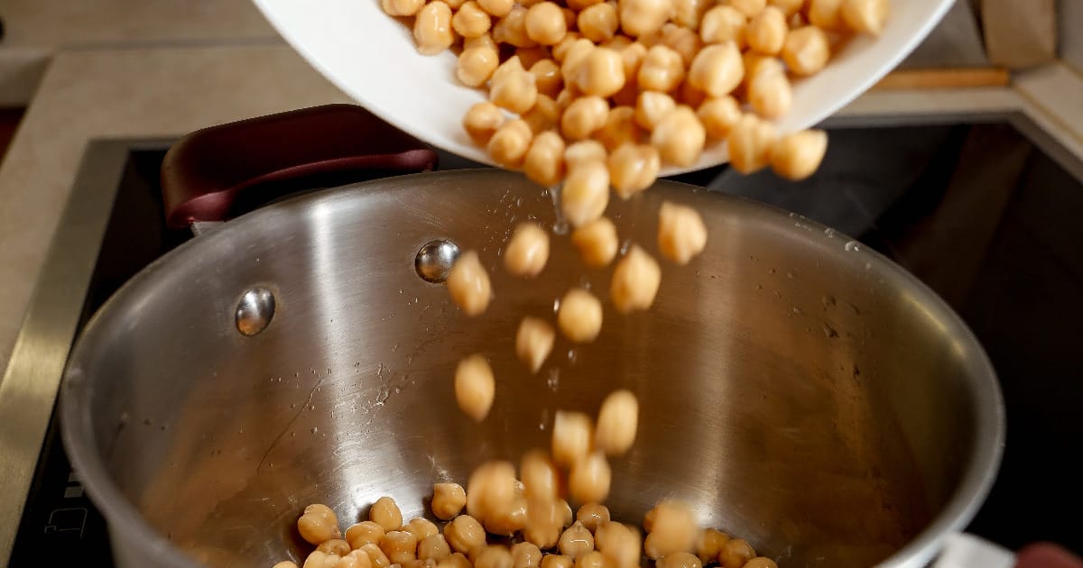 Pouring soaked beans into pot.