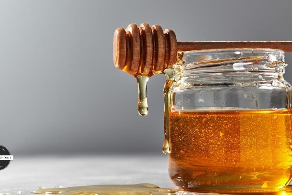 honey jar with spoon on gray background