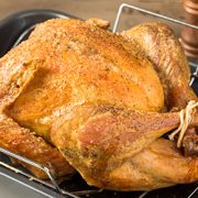Trusted, whole roasted turkey in roasting pan.