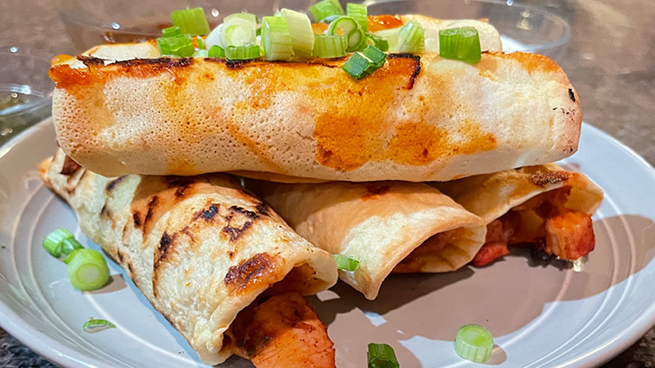 Close up of baked chicken taquitos on a plate. 