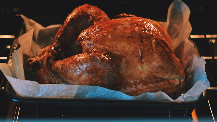 Whole turkey cooking in the oven.