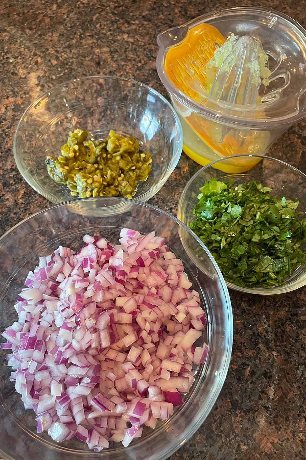 Avocado cucumber salsa recipe ingredients, measured out in bowls on countertop.