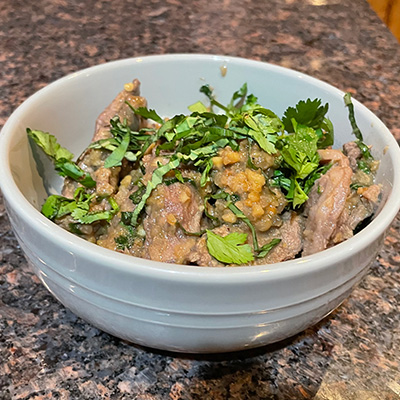 Close up view of Chinese beef with peanuts in a dish.