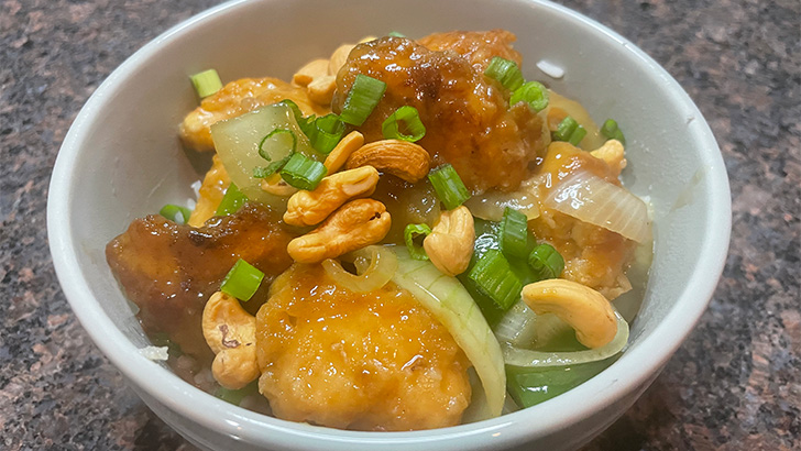 Close-up of prepared cashew chicken in bowl.