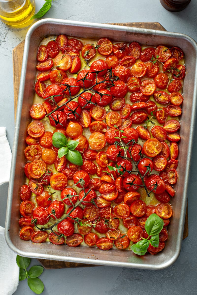 One of the best cherry tomato recipes -- roasted cherry tomatoes on baking sheet with herbs. 