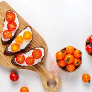 Top view of cherry tomatoes in bowl and sliced on toast.