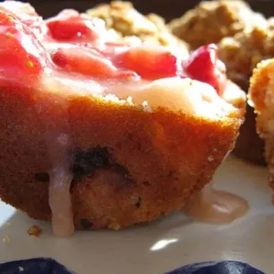 Strawberry muffin that's cut open with melted strawberry butter.