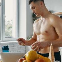 Man measures his food in kitchen.