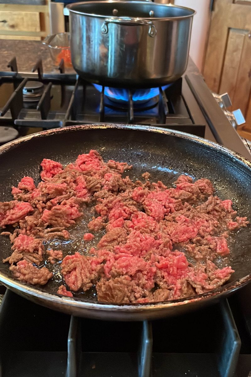 Ground beef for taco stuffed shells in a skillet.