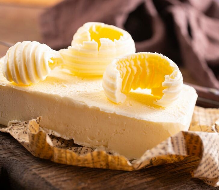 Fresh butter on paper atop a cutting board.