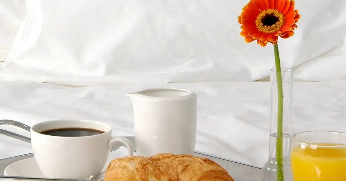 Breakfast on a tray with a fresh flower.