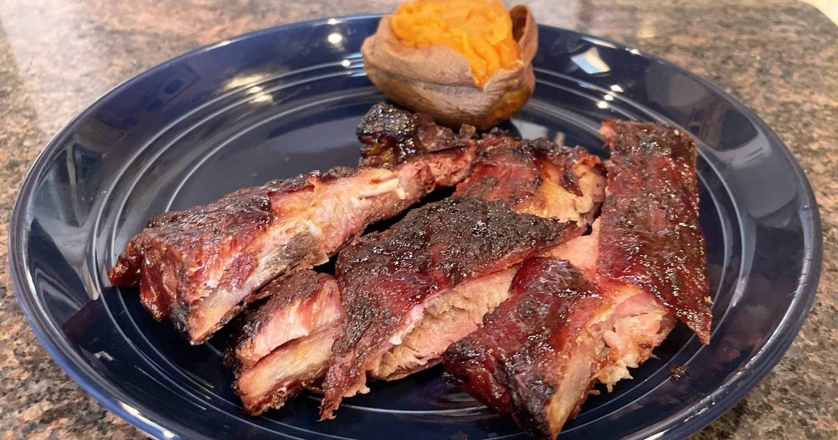 321 smoked spare ribs, prepared on plate with sweet potato.