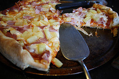 Baked Hawaiian pizza with a slice removed