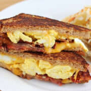 Breakfast grilled cheese with bacon, egg, and cheese on a plate with hash browns